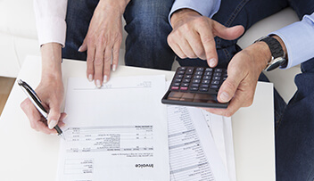 Stock photo - woman and man reviewing paperwork with calculator.