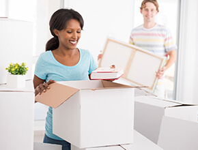 Stock Photo - woman and man unpacking boxes.