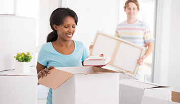 Stock Photo - woman and man unpacking boxes.