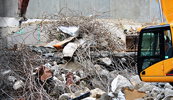 Stock photo - rebar and concrete construciton desbris with heavy machinery.