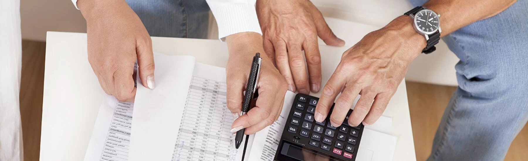 Stock photo - woman and man reviewing paperwork with calculator.