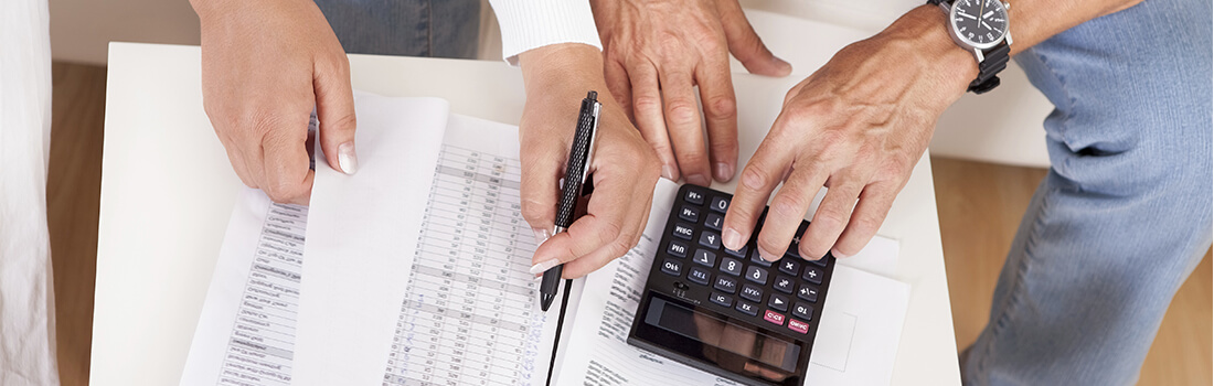 Stock photo - woman and man reviewing paperwork with calculator.