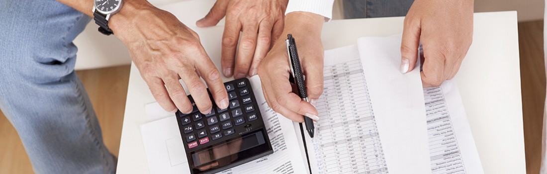 Stock photo - woman and man reviewing paperwork with calculator.